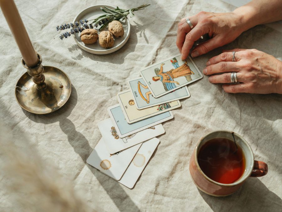 Manos barajando cartas de tarot sobre un mantel de lino
